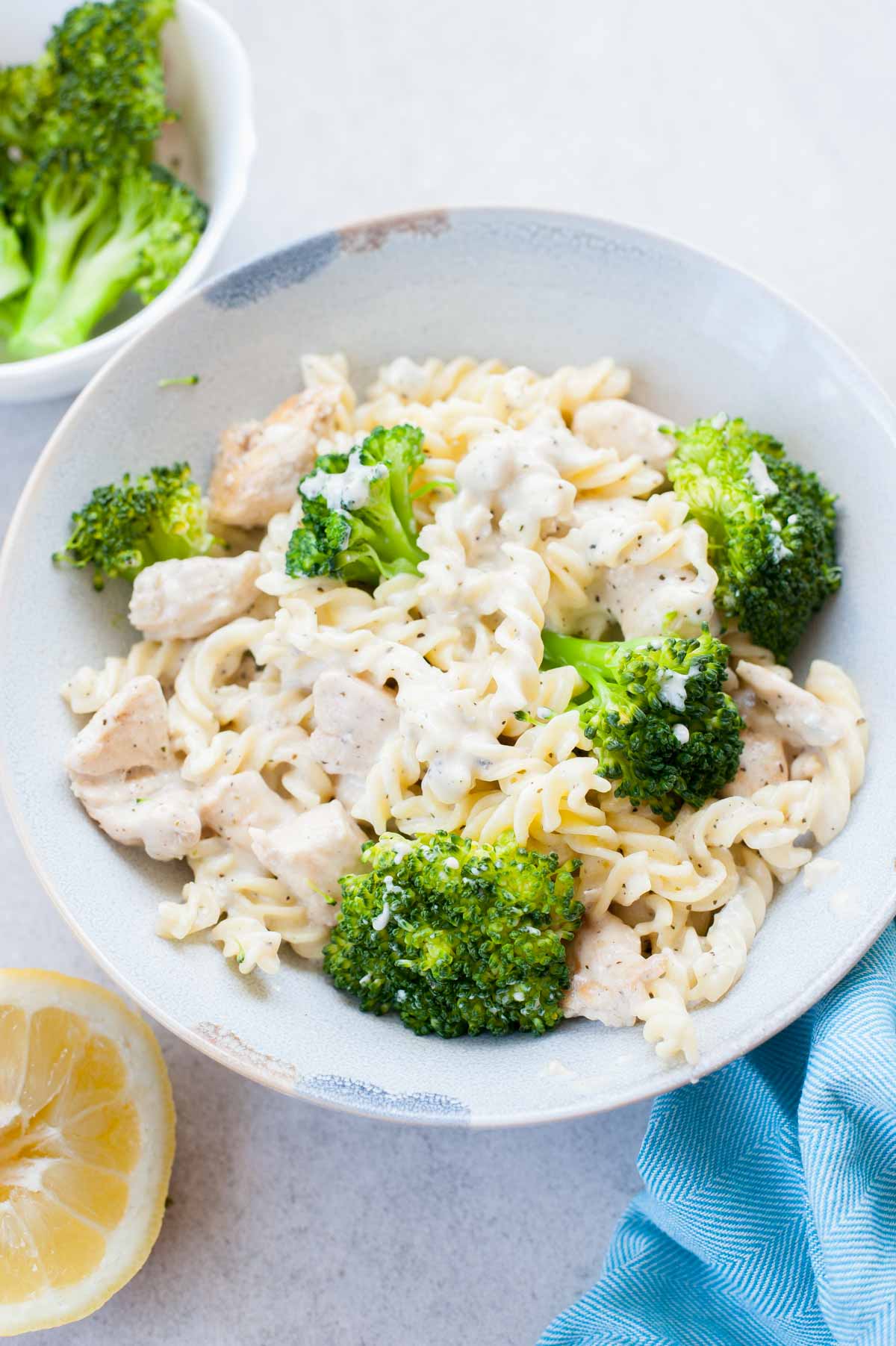 Four cheese pasta with chicken and broccoli in a blue plate.