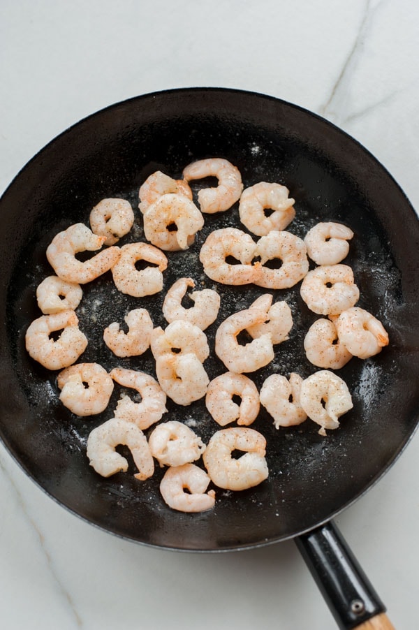 Cooked shrimp in a black frying pan.