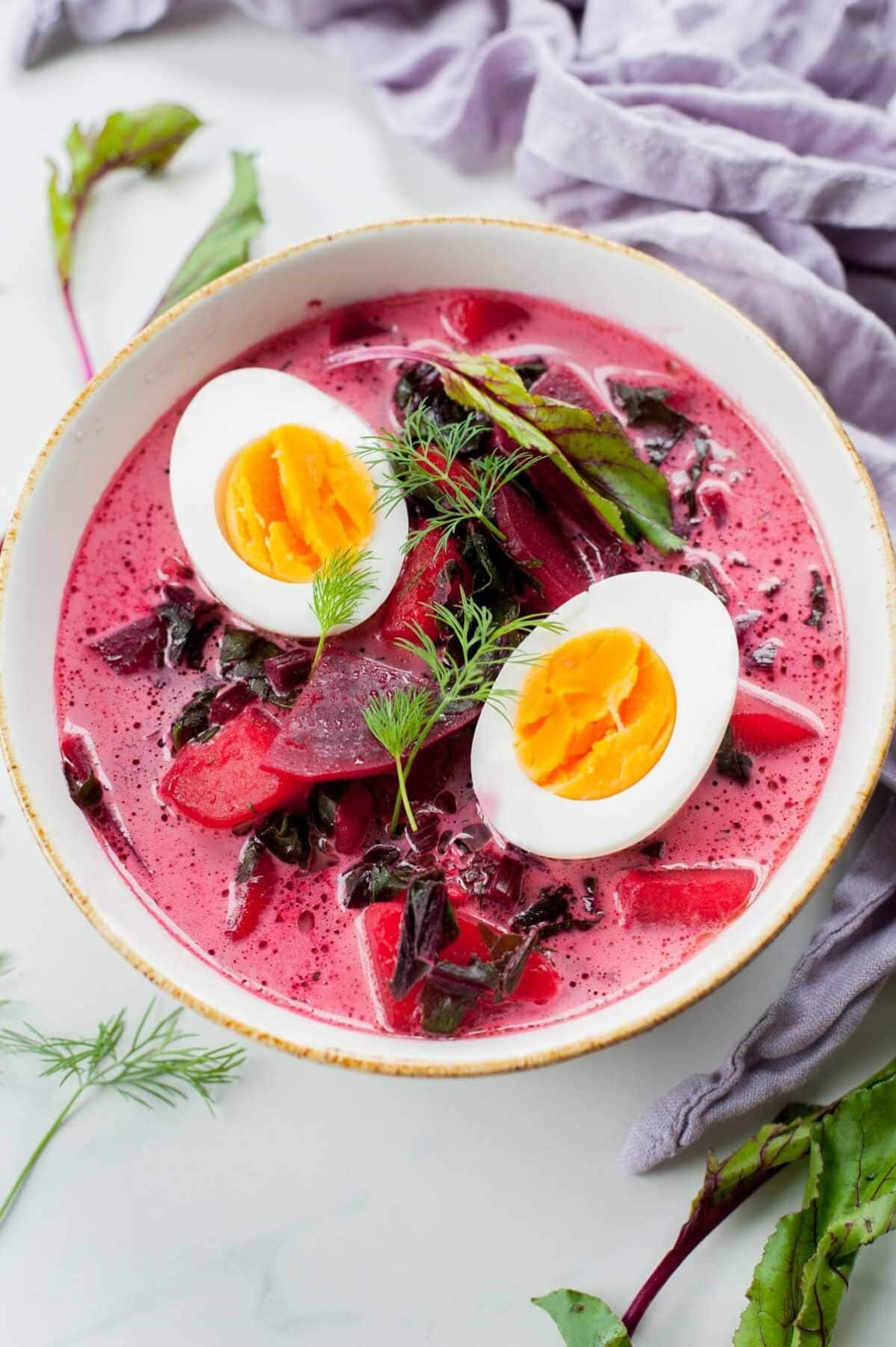 young beets soup with hard-boiled eggs in a white bowl