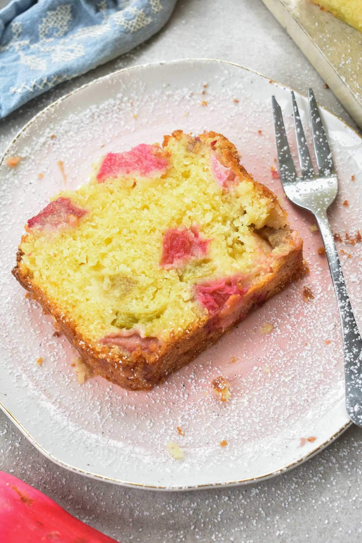 a slice of rhubarb cake on a rose plate