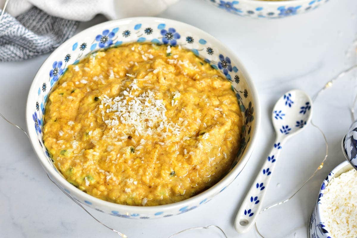 Banana oatmeal with passion fruit in a white bowl with blue flowers.