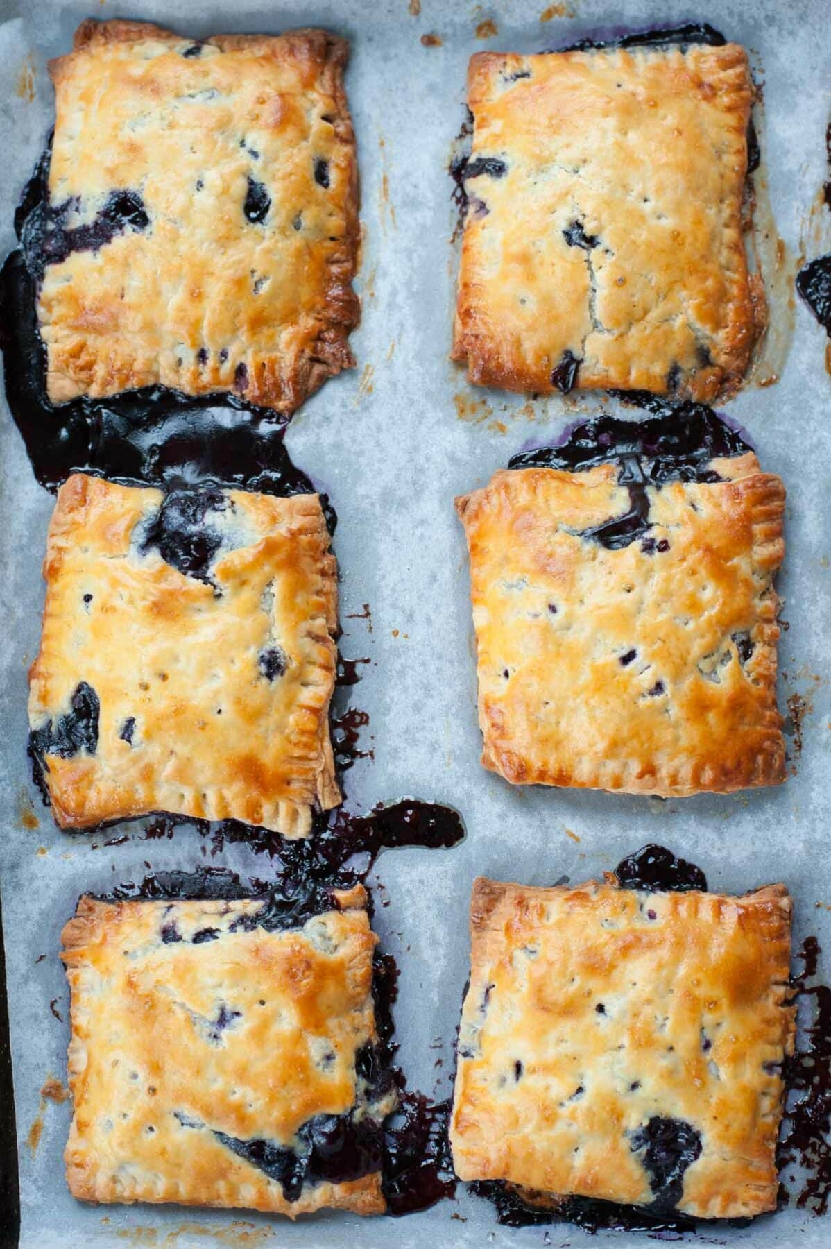 freshly baked blueberry hand pies on a baking paper