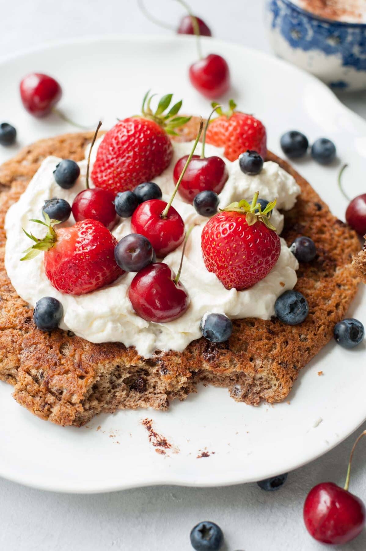 chocolate omelet with whipped cream and mixed berries on a white plate