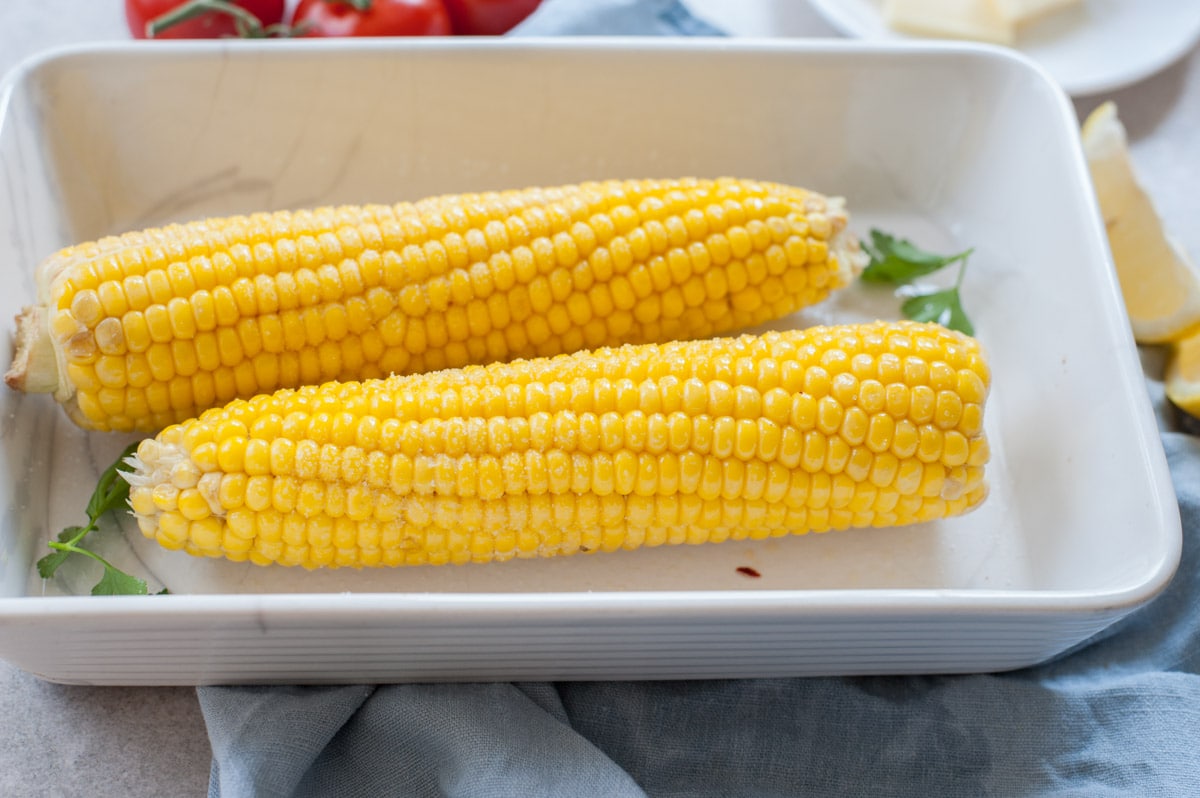 corn on the cob in a white baking dish