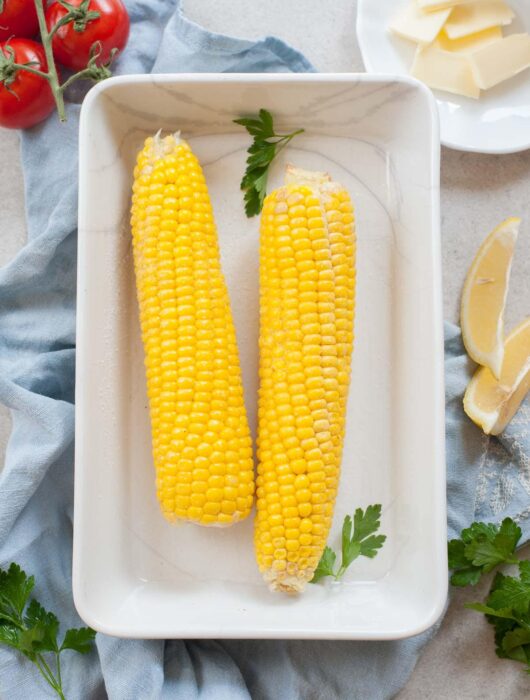 corn on the cob in a white baking dish