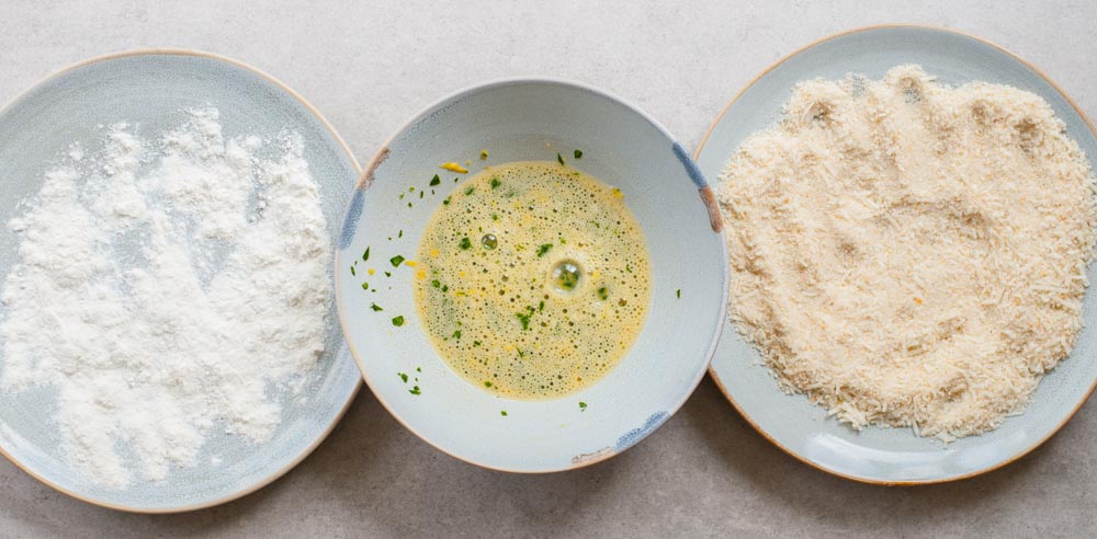 Ingredients for the breading in three plates.