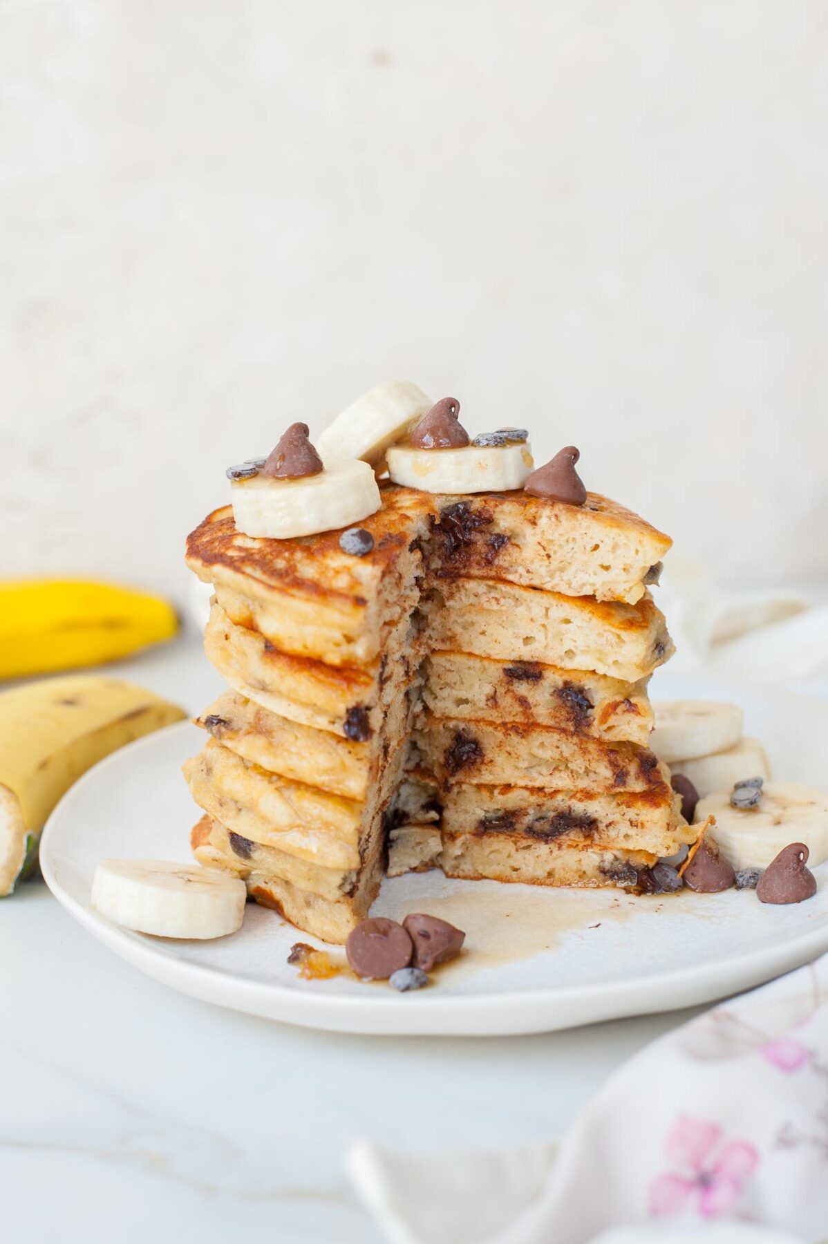 a stack of banana chocolate chip pancakes with a quarter cut off