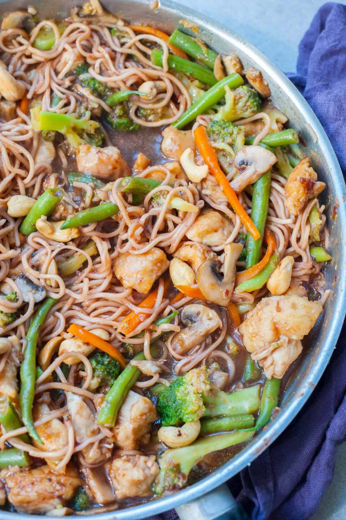 chicken, noodles, vegetables and Chinese plum sauce in a frying pan