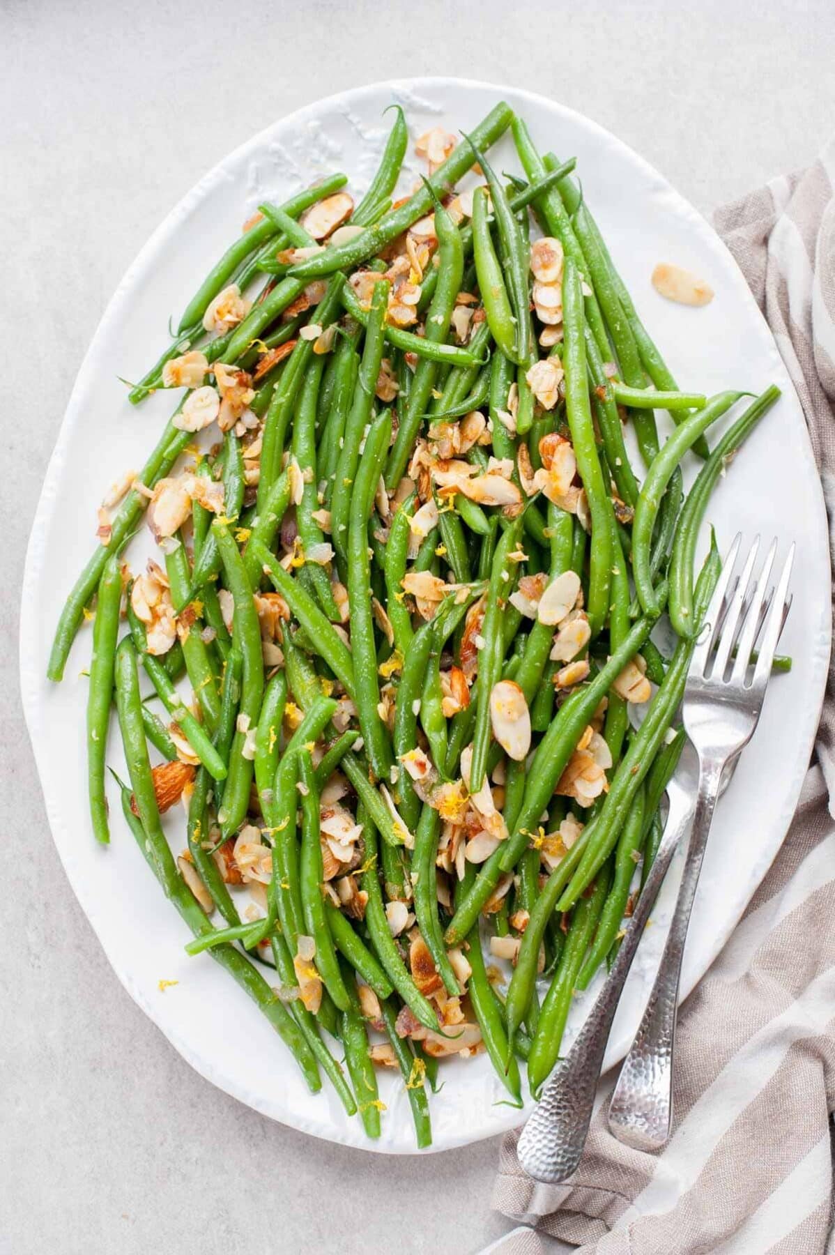 green beans with almonds, garlic and lemon on a big white plate