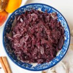 Braised red cabbage with apples in a blue bowl.