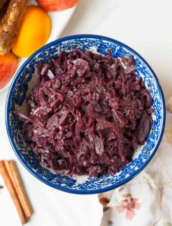 Braised red cabbage with apples in a blue bowl.