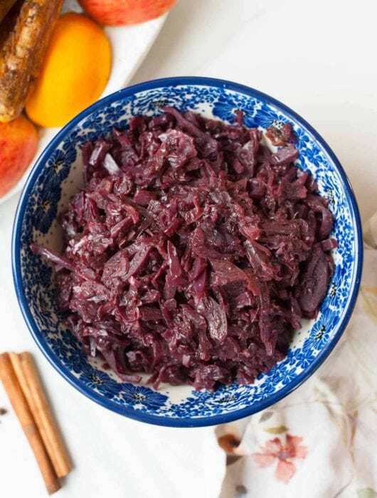 Braised red cabbage with apples in a blue bowl.