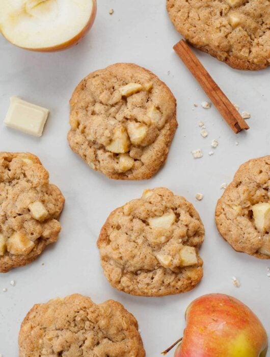 Apple cinnamon oatmeal cookies on a white background. Apples, cinnamon stick, oats on the side.
