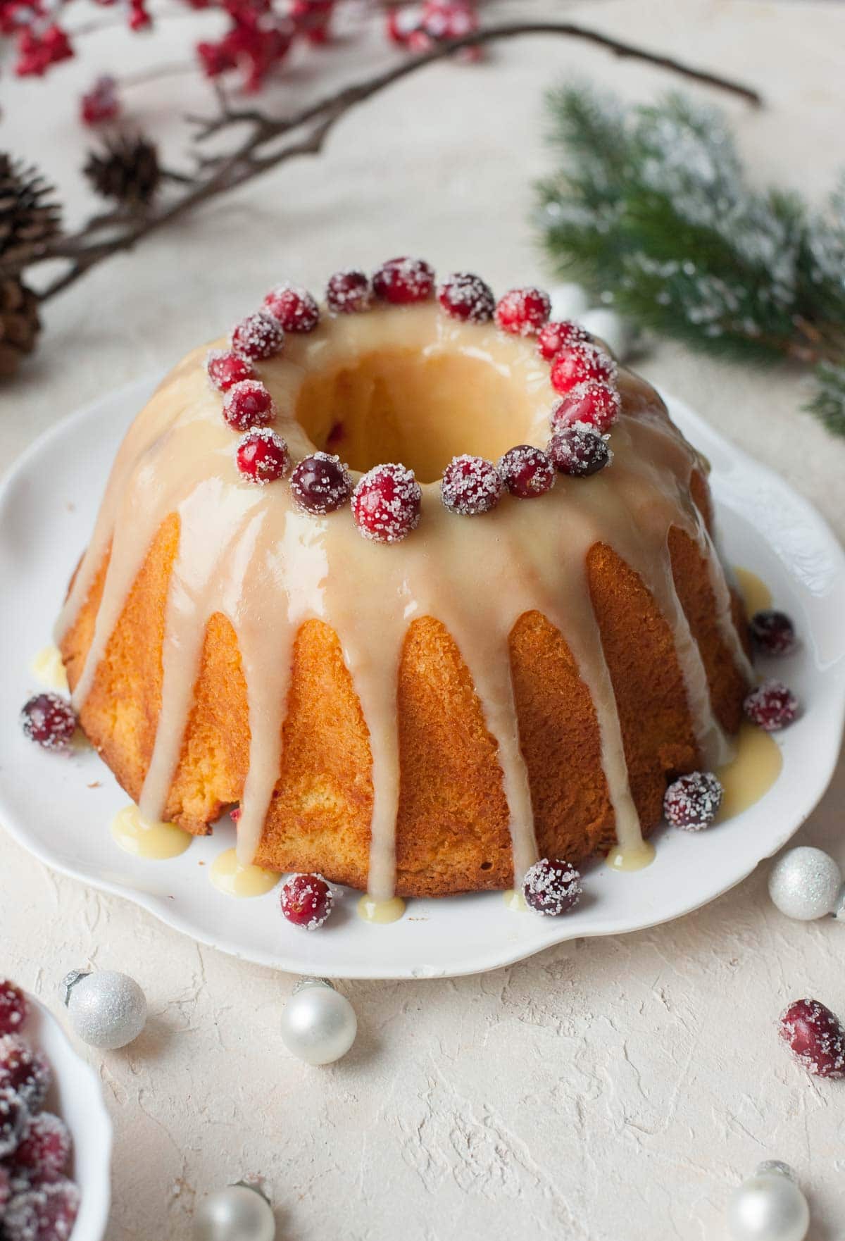 Cranberry orange bundt cake with white chocolate orange glaze and sugared cranberries.