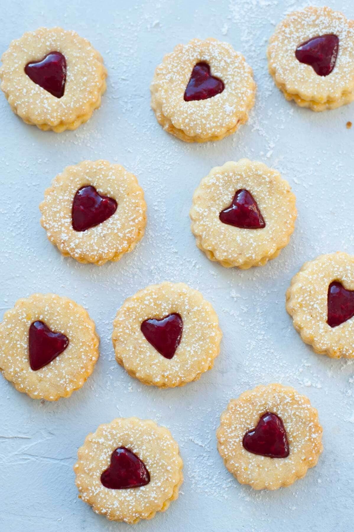 Ciastka Linzer w kształcie serca na niebieskim tle.