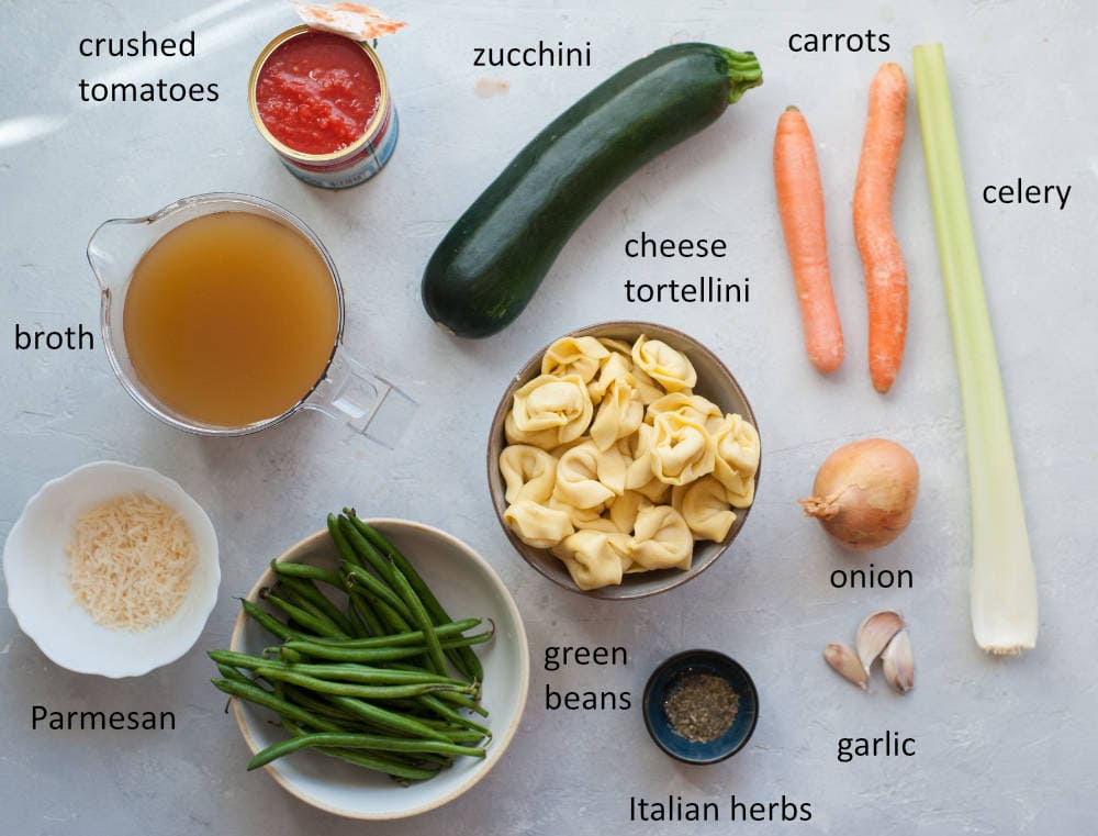Labeled ingredients needed to prepare vegetable tortellini soup.