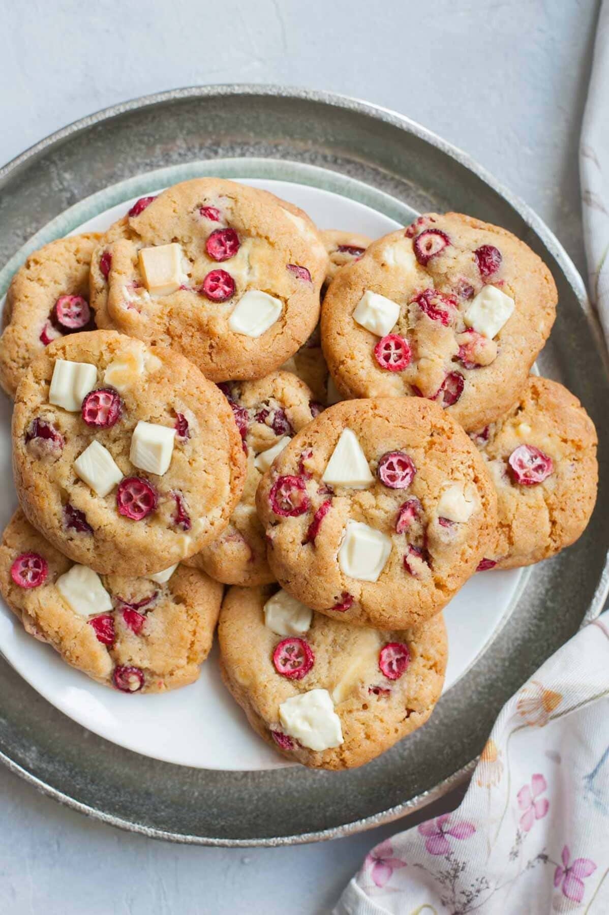 Fresh cranberry white chocolate cookies on a silver plate.