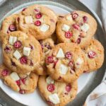 Fresh cranberry white chocolate cookies on a silver tray.