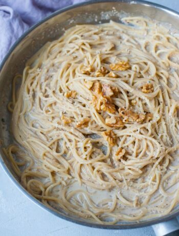 Gorgonzola walnut pasta in a frying pan topped with walnuts.