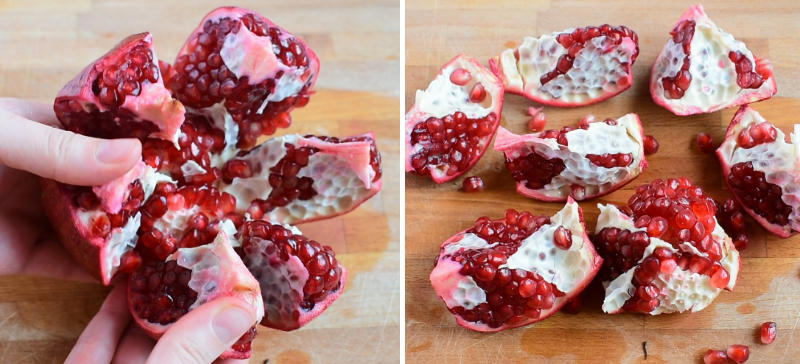 Pomegranate is being divided into segments. Pomegranate segments on a wooden board.