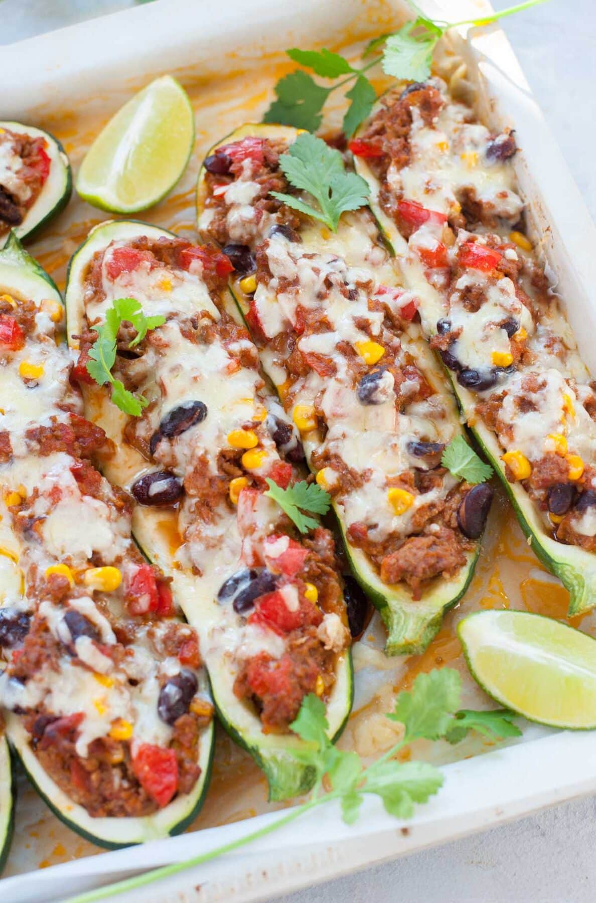 Mexican zucchini boats in a white baking pan topped with cilantro.