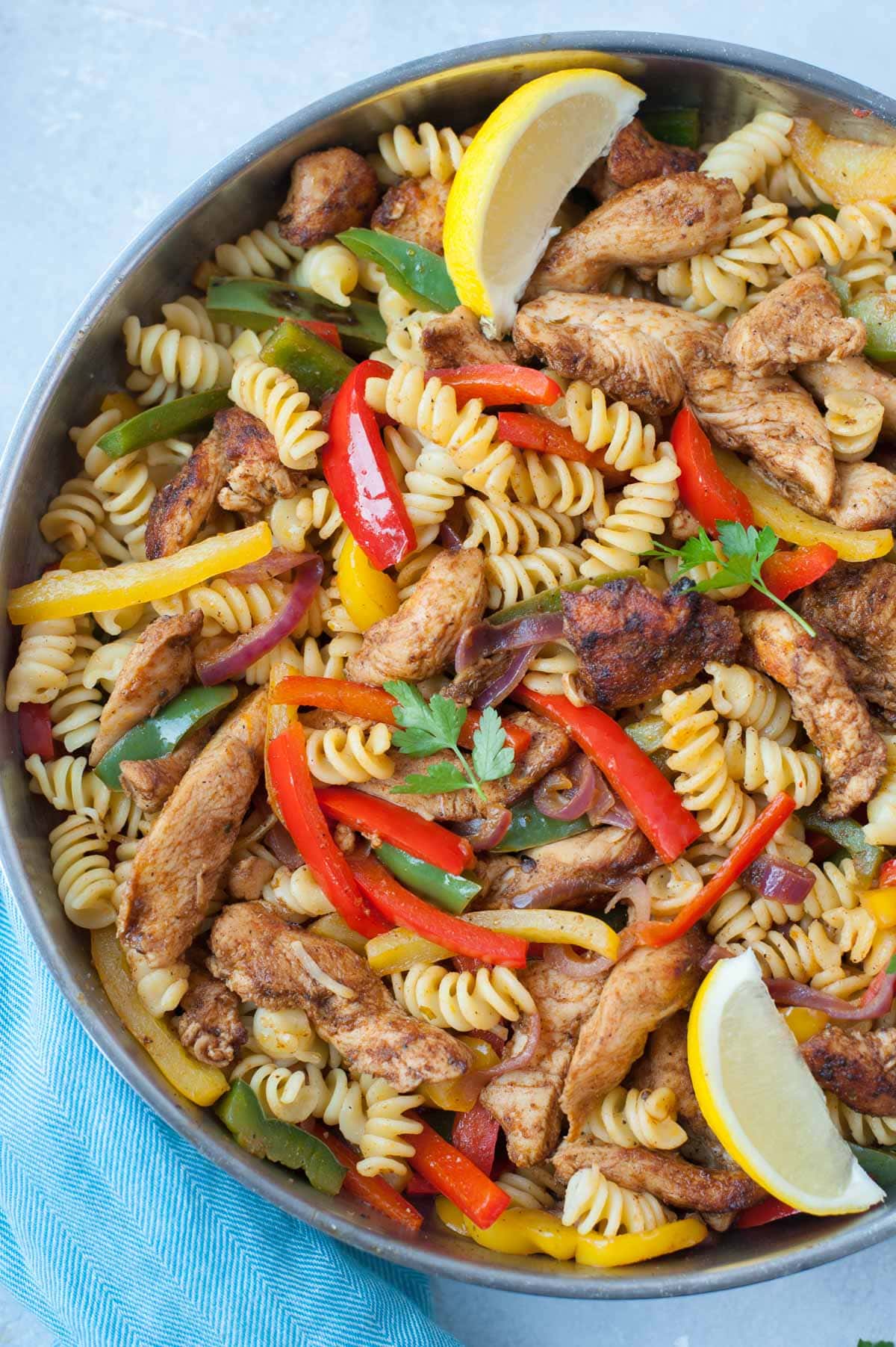 A close up picture of chicken fajita pasta in a frying pan.