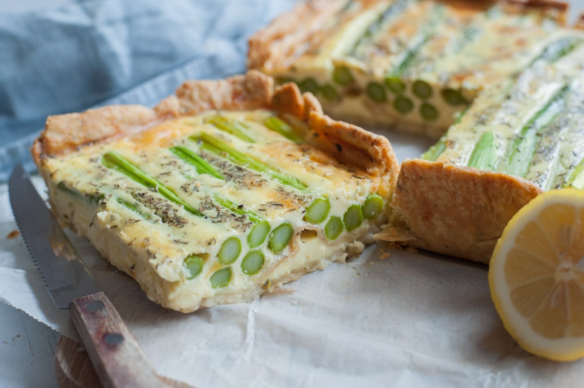 A piece of asparagus quiche on parchment paper.