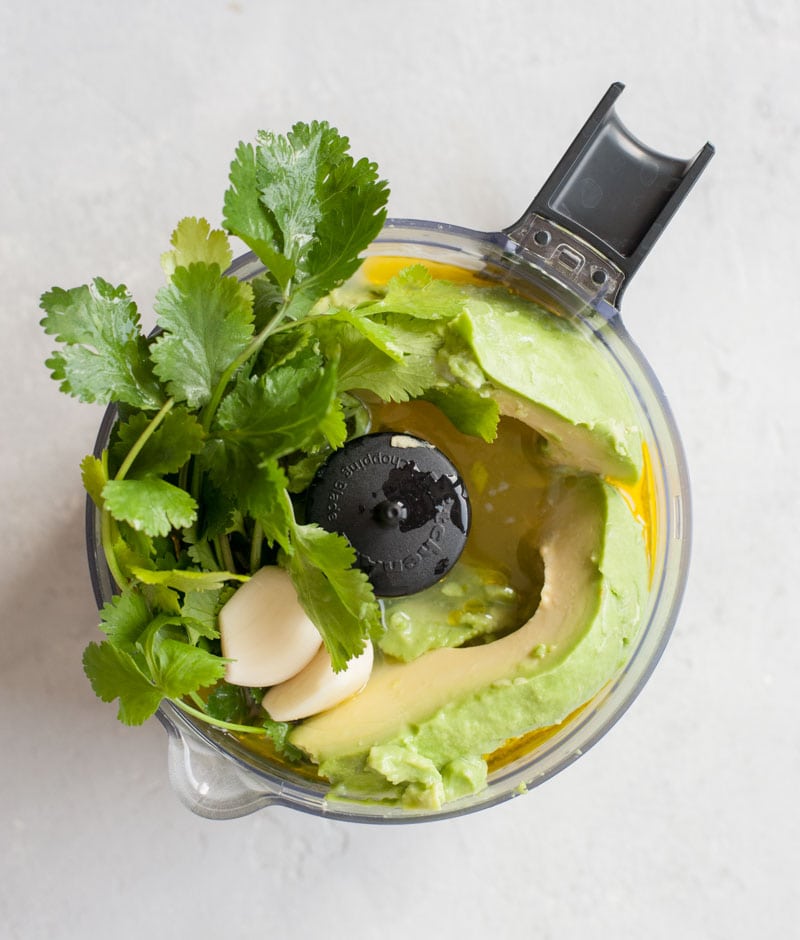 All the ingredients for avocado cilantro lime dressing in a food processor.