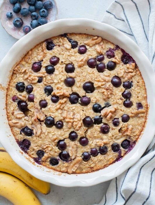 Banana blueberry baked oatmeal in a white baking dish.