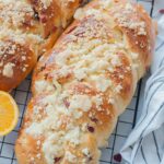 Two loaves of braided brioche bread on a cooling rack.