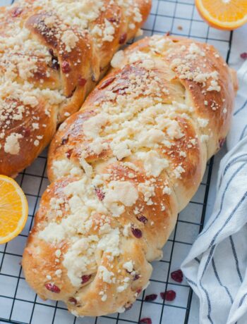 Two loaves of braided brioche bread on a cooling rack.