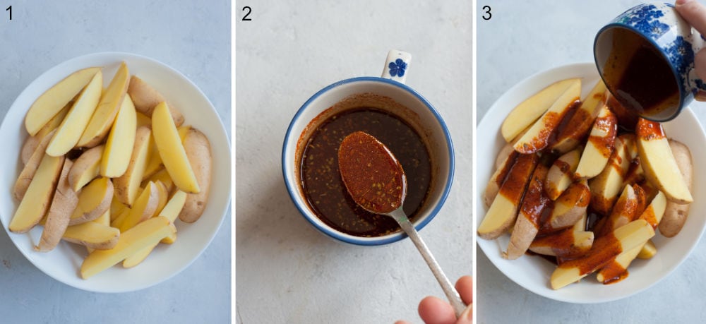 Potato wedges in a bowl. Spices with olive oil in a cup. Spiced olive oil is being drizzled over potatoes.