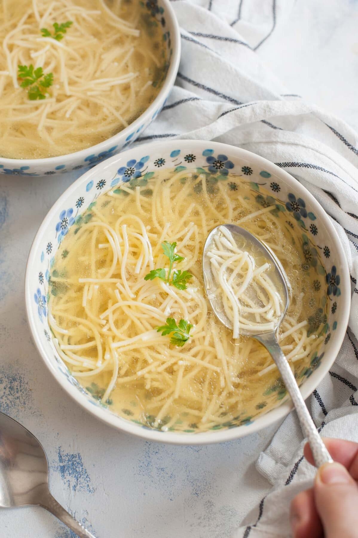 Two bowl with rosol soup served with pasta.