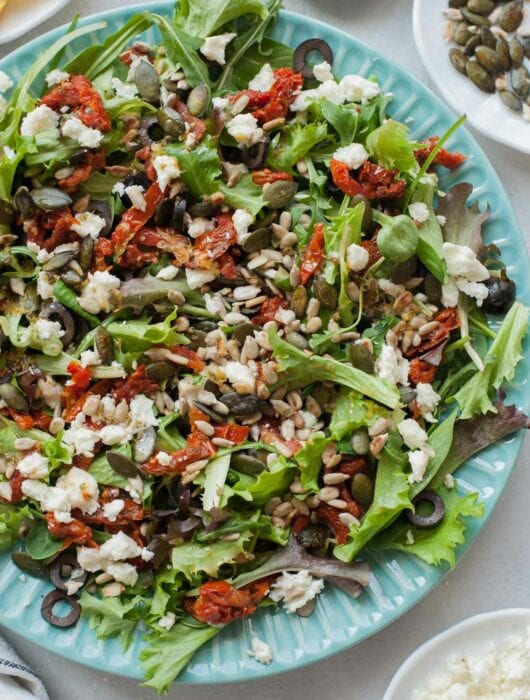 Sun-dried tomato salad on a green plate.