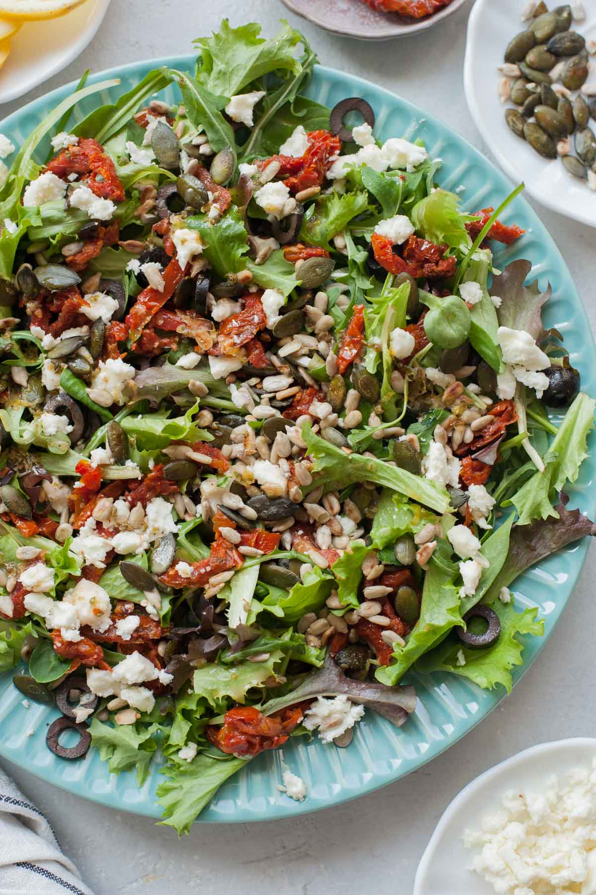 Sun-dried tomato salad on a green plate.