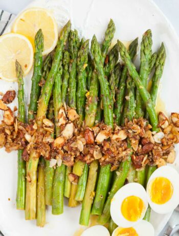 Asparagus almondine topped with almonds garlic. Hard-boiled eggs and lemon slices on the side.