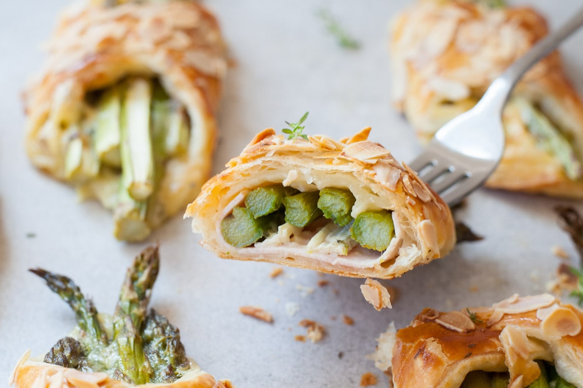 Asparagus in puff pastry with ham and cheese cut in half.