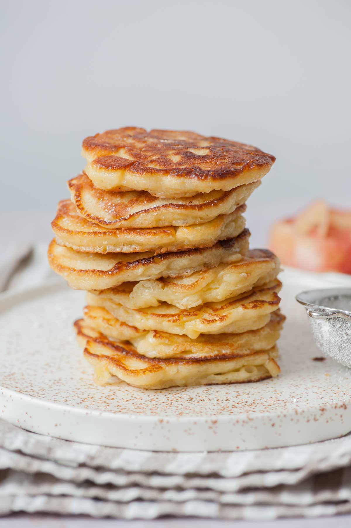 A stack of apple pancakes on a white plate.