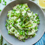 Asparagus risotto with peas in a violet bowl.