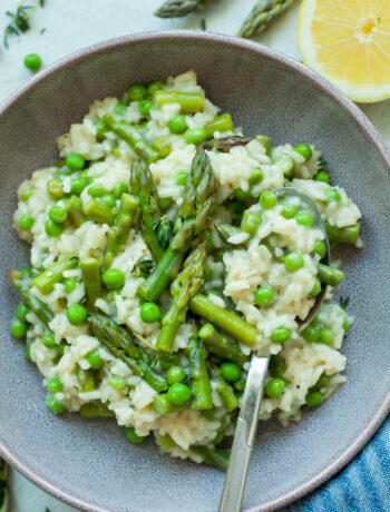 Asparagus risotto with peas in a violet bowl.