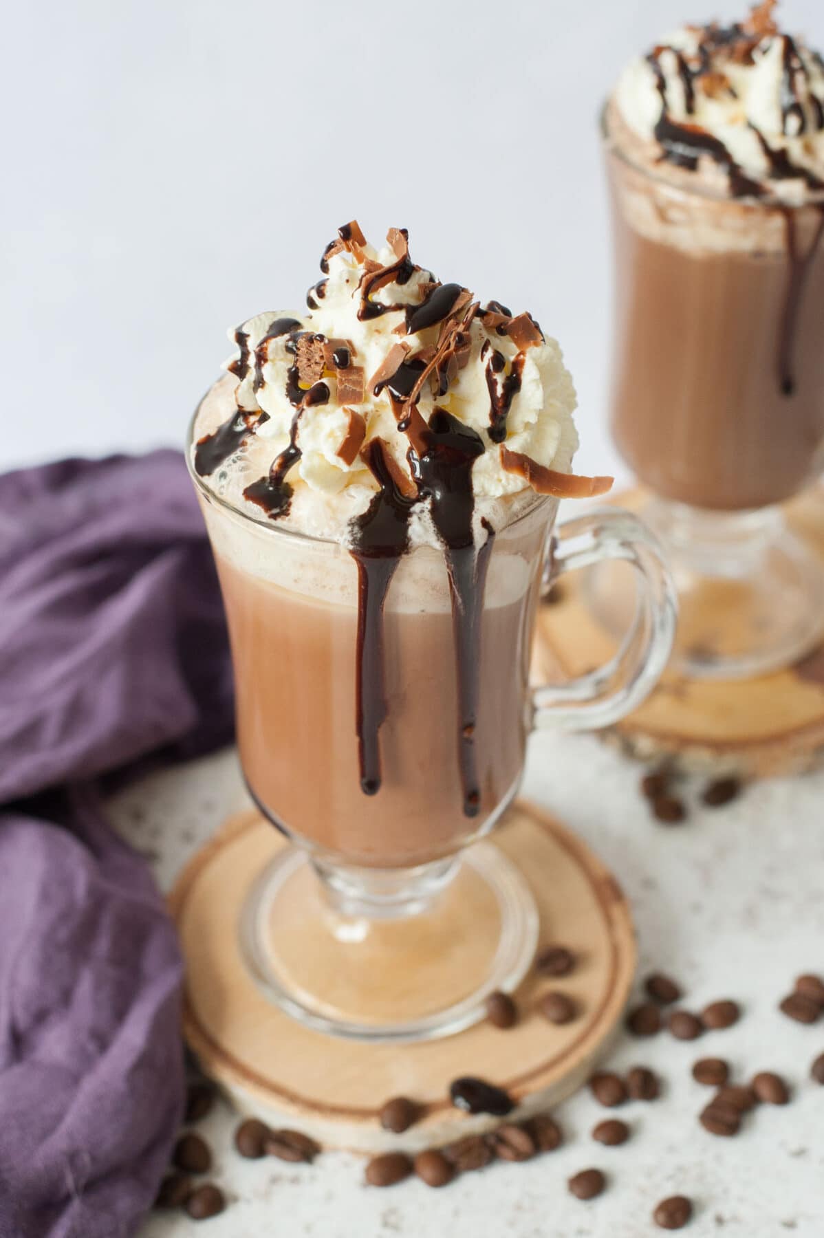 Coffee mocha topped with whipped cream and chocolate sauce in a cup.