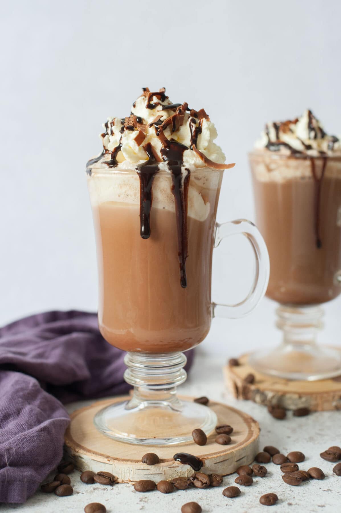 Coffee mocha topped with whipped cream and chocolate sauce in a cup.