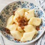 Kopytka with buttered breadcrumbs in a white-blue bowl.