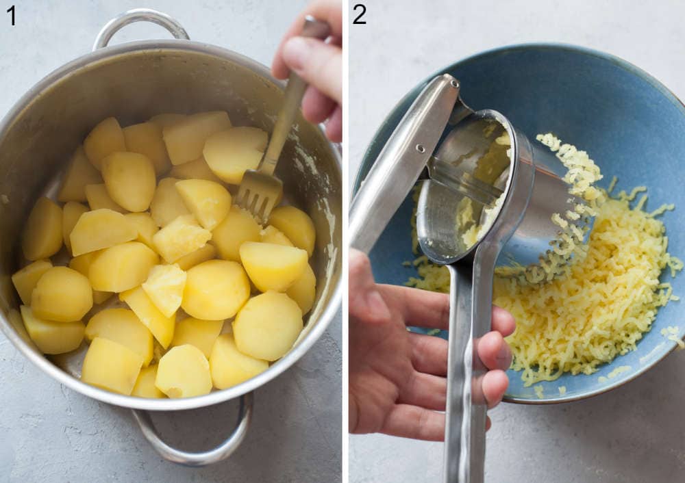 Cooked potatoes in a pot. Potatoes are being mashed with potato ricer.