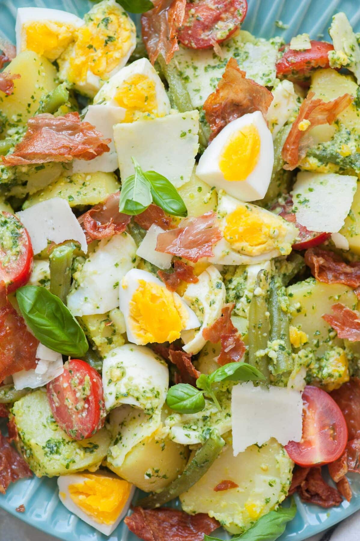 A close up picture of pesto potato salad on a blue plate.