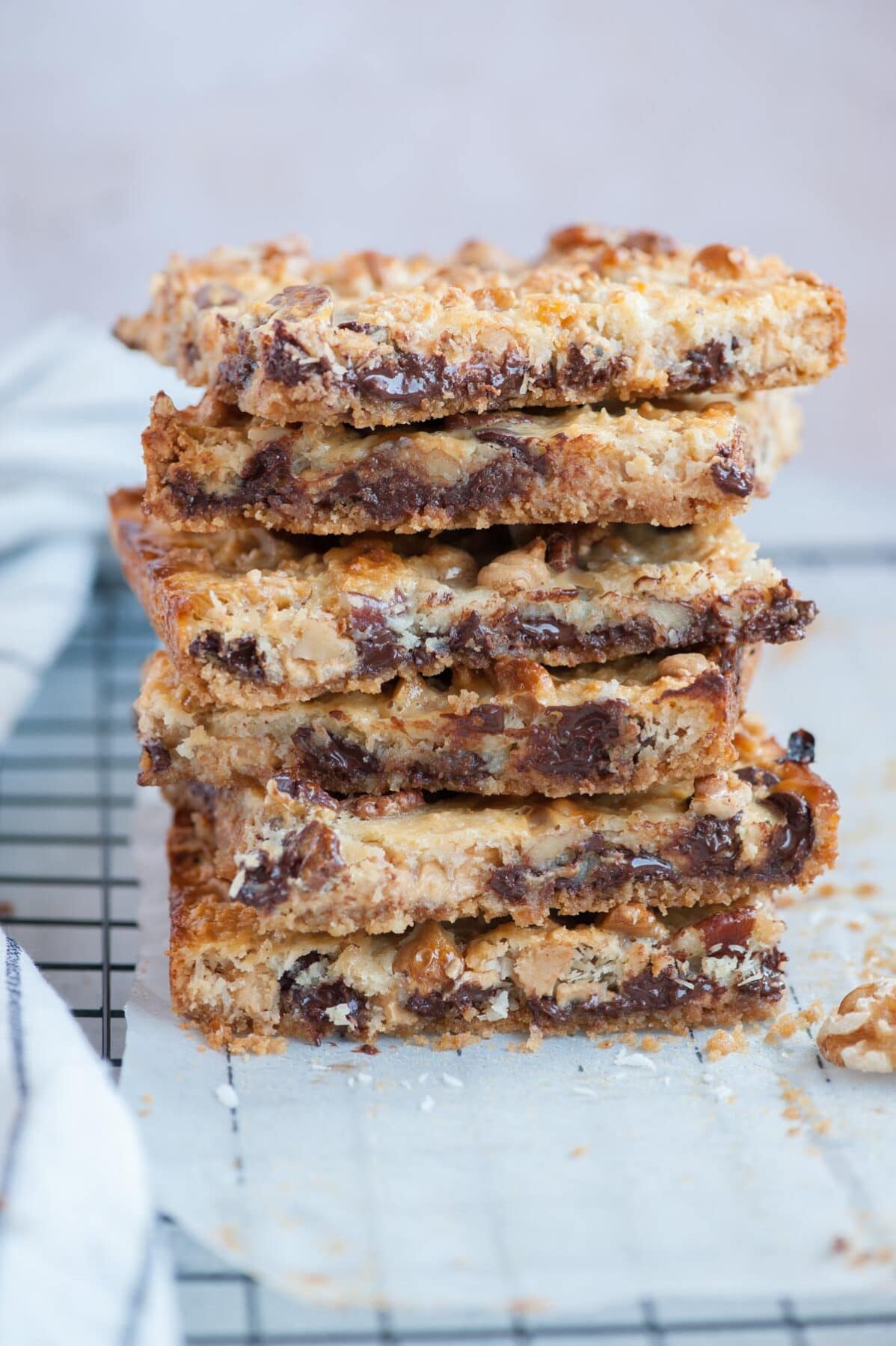 A stack of 7-layer Magic Bars on a piece of parchment paper.
