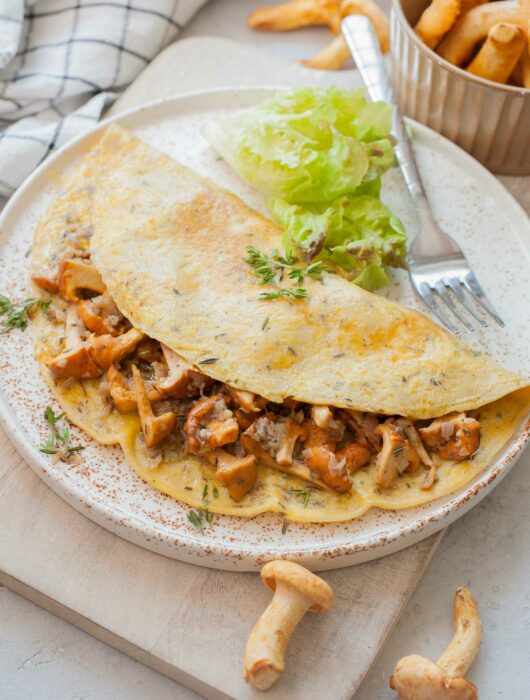 Chanterelle mushroom omelette on a white plate.