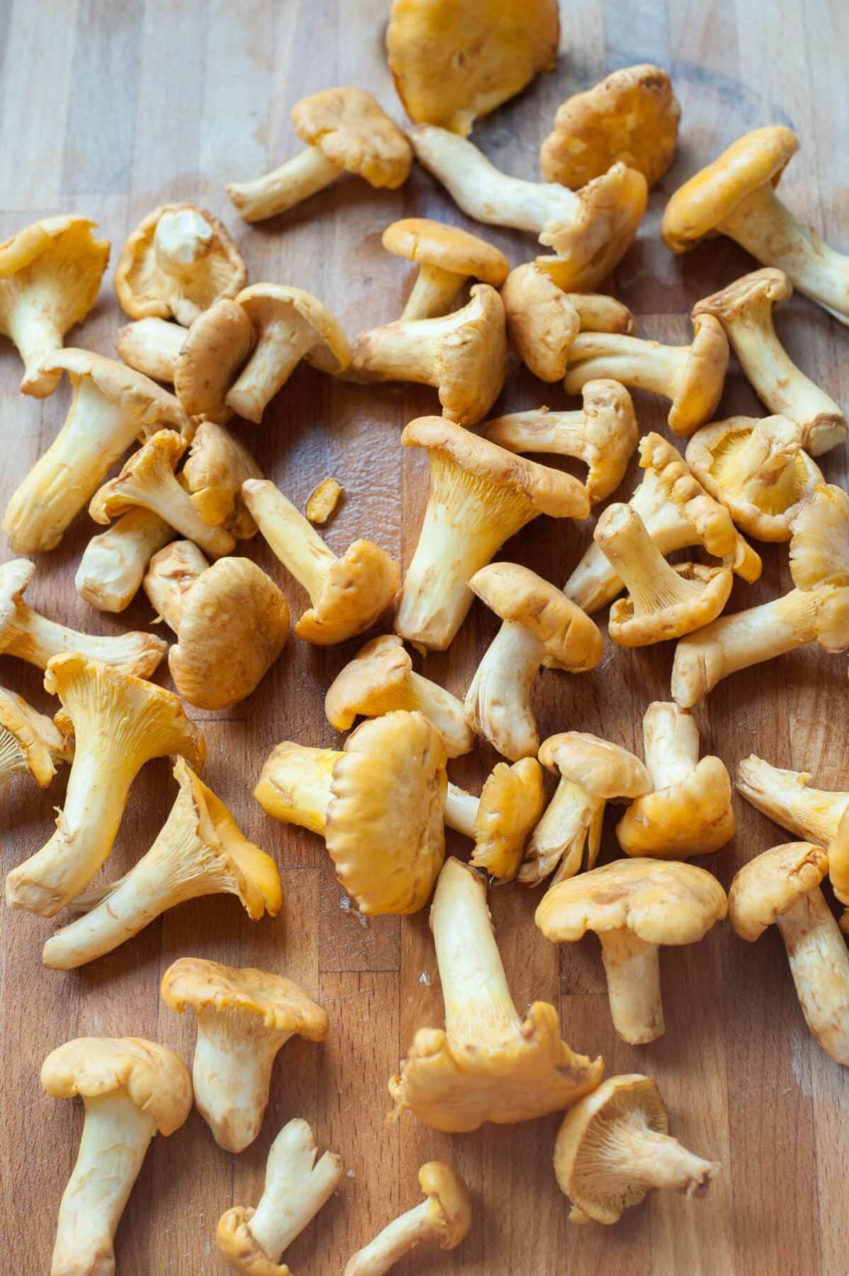 Chanterelle mushrooms on a wooden chopping board.