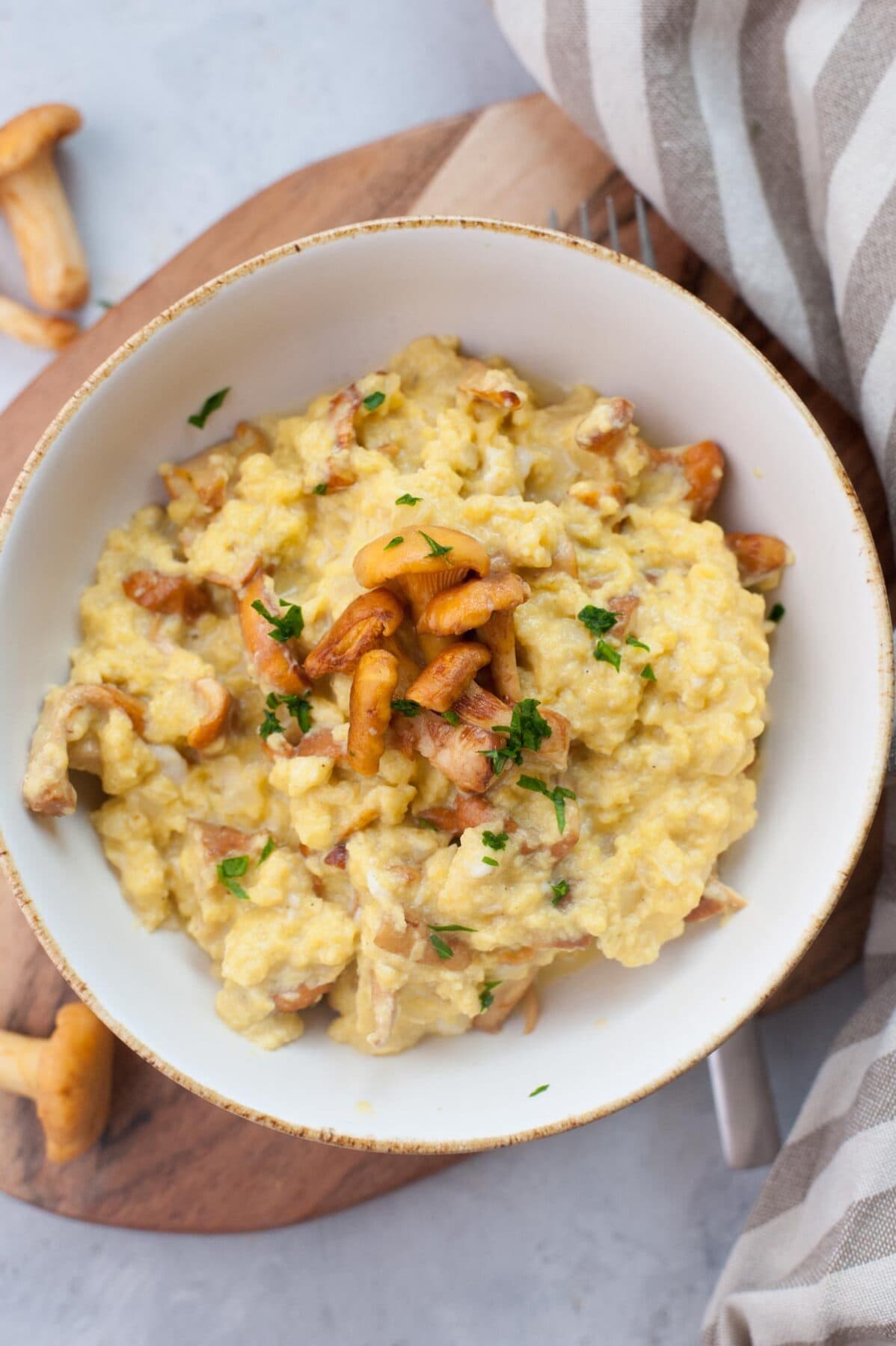 Chanterelle scrambled eggs in a white bowl.