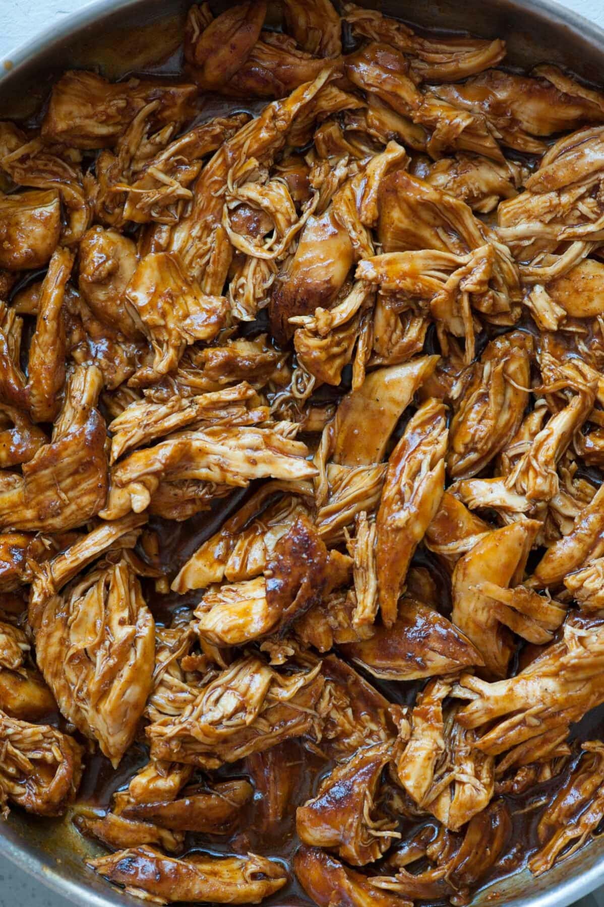 A close up photo of bbq pulled chicken in a pan.